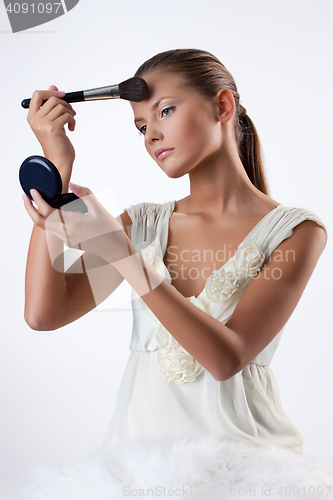 Image of Young Woman Applying Cosmetics