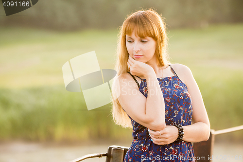 Image of Portrait of a pensive modest girl on blurred green background