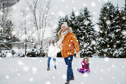 Image of happy family with sled walking in winter outdoors