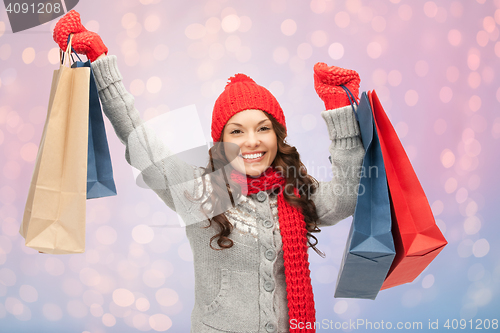 Image of woman with shopping bags over christmas lights 