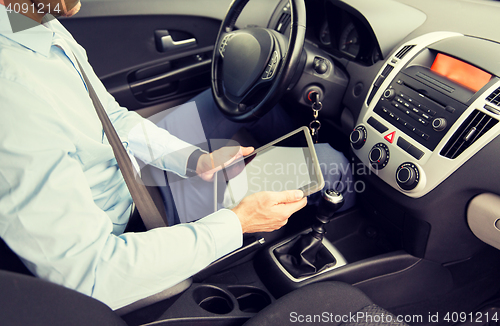 Image of close up of young man with tablet pc driving car