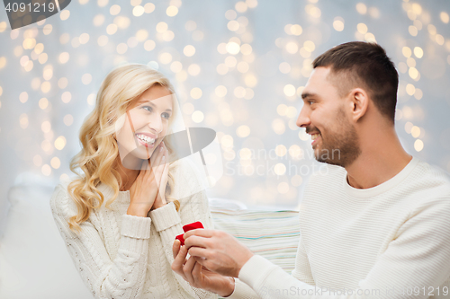 Image of happy man giving engagement ring to woman