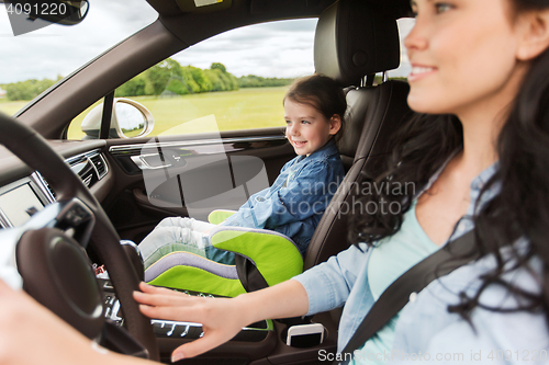 Image of happy woman with little child driving in car