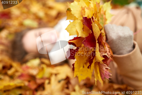 Image of close up of happy woman lying on autumn leaves