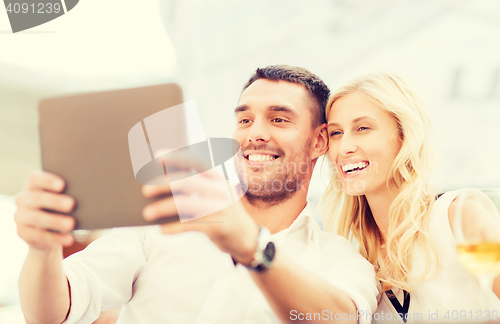 Image of happy couple with tablet pc at restaurant lounge