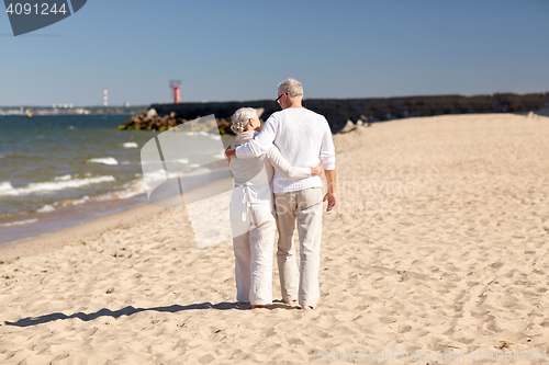 Image of happy senior couple hugging on summer beach