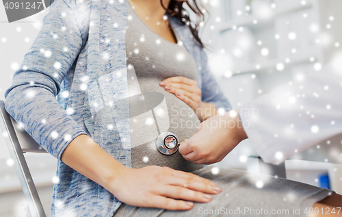 Image of doctor with stethoscope and pregnant woman belly