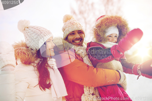 Image of happy family with child in winter clothes outdoors