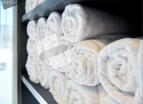 Image of rolled white bath towels at hotel spa