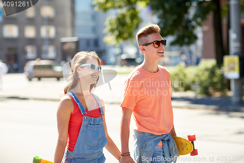 Image of teenage couple with skateboards on city street