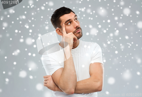 Image of man thinking over snow on gray background