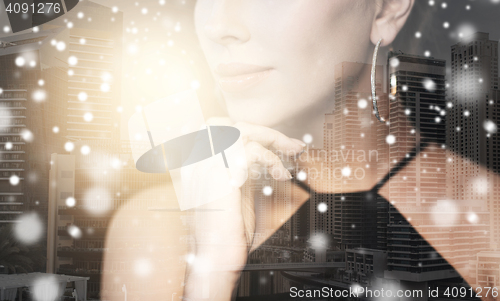 Image of beautiful woman with jewelry over city and snow