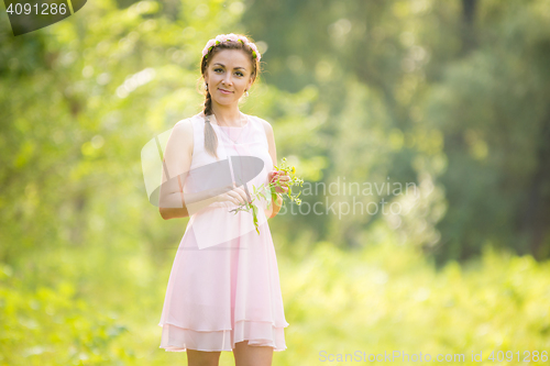 Image of Portrait of a young girl picking flowers in a meadow