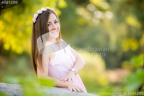 Image of Portrait of a beautiful young girl who was leaning on a fallen tree