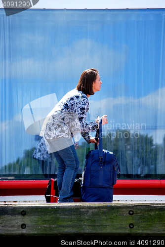 Image of Female tourist with luggage.