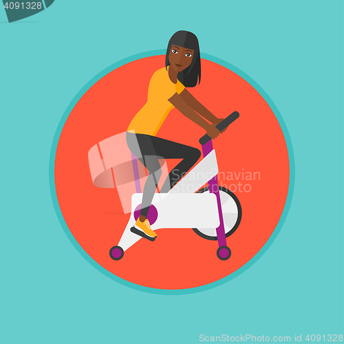 Image of Woman riding stationary bicycle.