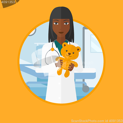 Image of Pediatrician doctor holding teddy bear.