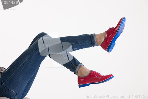 Image of Woman\'s Legs In Blue Jeans And Red Shoes