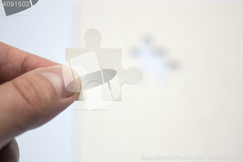 Image of Hand holds suitable piece of puzzle