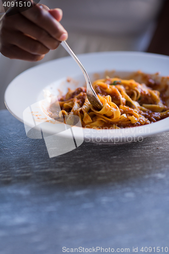 Image of a young African American woman eating pasta