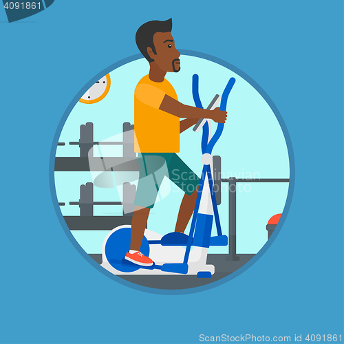 Image of Man exercising on elliptical trainer.