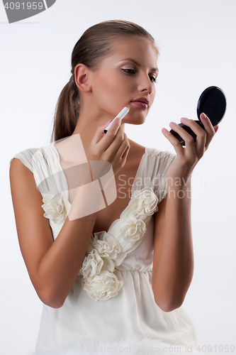 Image of Young Woman Applying Cosmetics