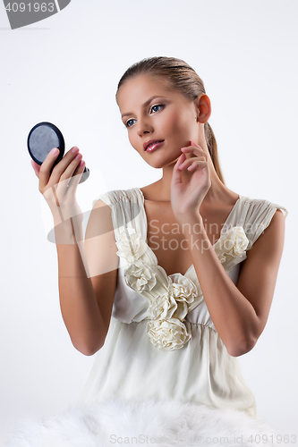 Image of Young Woman Looking In The Mirror