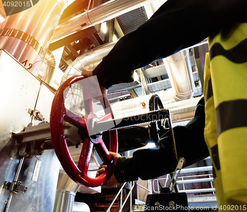 Image of factory worker turning valve