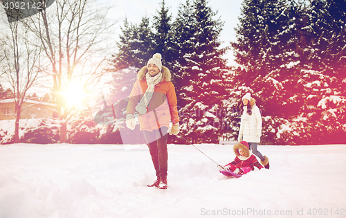 Image of happy family with sled walking in winter outdoors