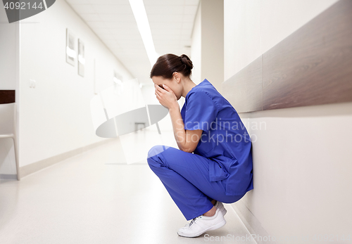 Image of sad or crying female nurse at hospital corridor