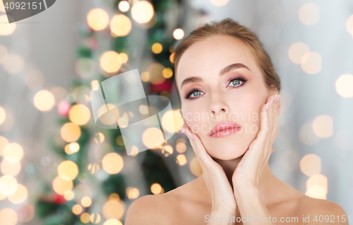 Image of beautiful woman face over christmas lights
