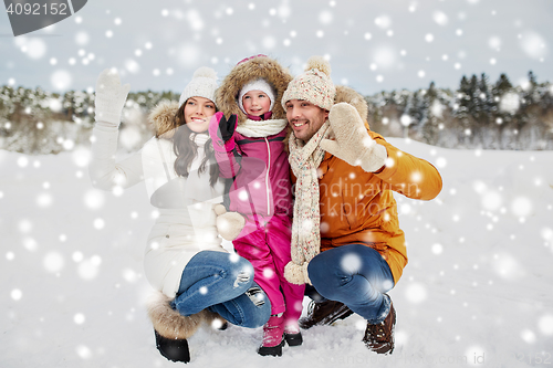 Image of happy family waving hands outdoors in winter