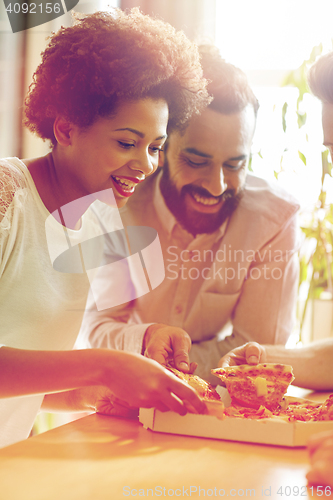 Image of happy business team eating pizza in office