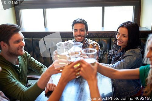 Image of happy friends drinking beer at bar or pub