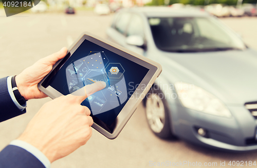 Image of close up of man with tablet pc diagnoses car