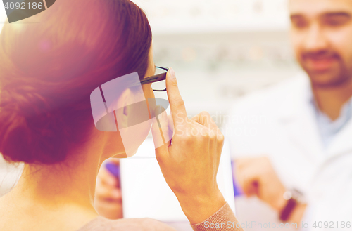 Image of close up of woman choosing glasses at optics store