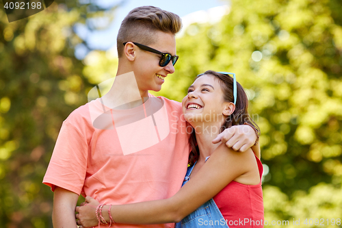 Image of happy teenage couple looking at each other in park