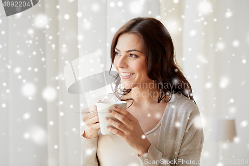 Image of happy woman with cup of tea or coffee at home