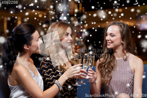 Image of happy women with champagne glasses at night club