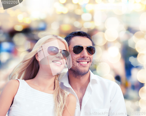 Image of happy couple in shades over lights background