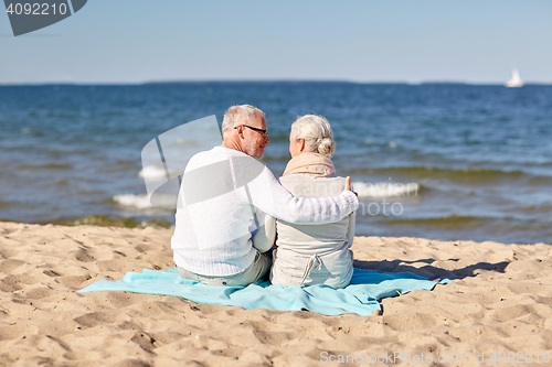 Image of happy senior couple hugging on summer beach