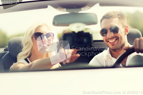 Image of happy couple usin gps navigation system in car
