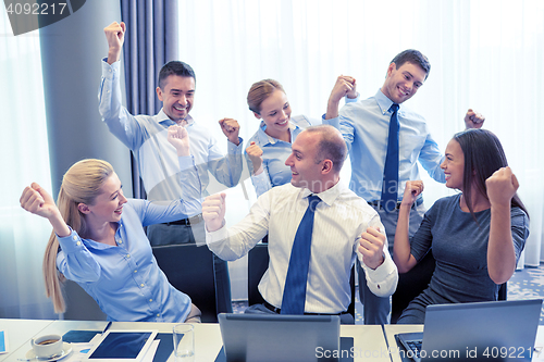 Image of business people celebrating victory in office