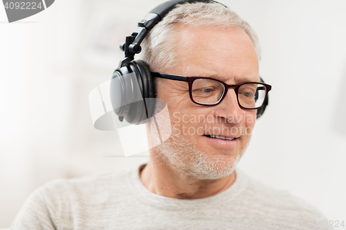 Image of happy man in headphones listening to music at home