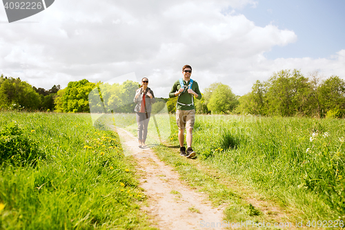 Image of happy couple with backpacks hiking outdoors
