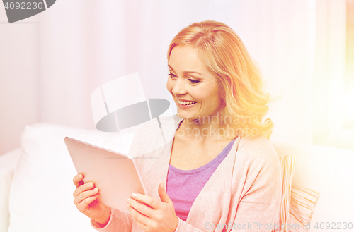 Image of happy middle aged woman with tablet pc at home