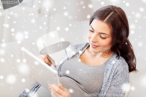 Image of pregnant woman with tablet pc and credit card