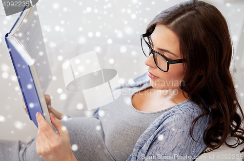 Image of pregnant woman reading book at home