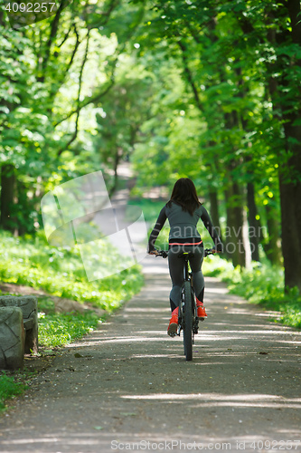 Image of cyclist woman riding a bicycle in park