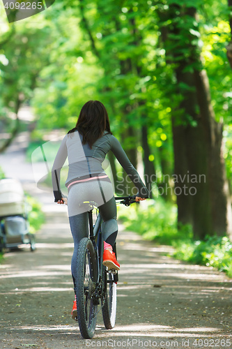 Image of cyclist woman riding a bicycle in park